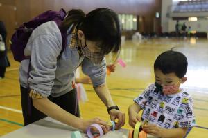 紙飛行機を作る親子連れ