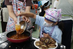 ハンバーグを煮込む子供